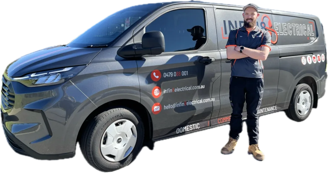 Joel, a Rivervale electrician from Infin8 Electrical, standing beside a grey Infin8 Electrical branded service van